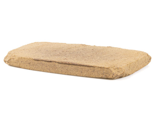 Bloc de hash CBD à l'aspect sec et orangé sur fond blanc